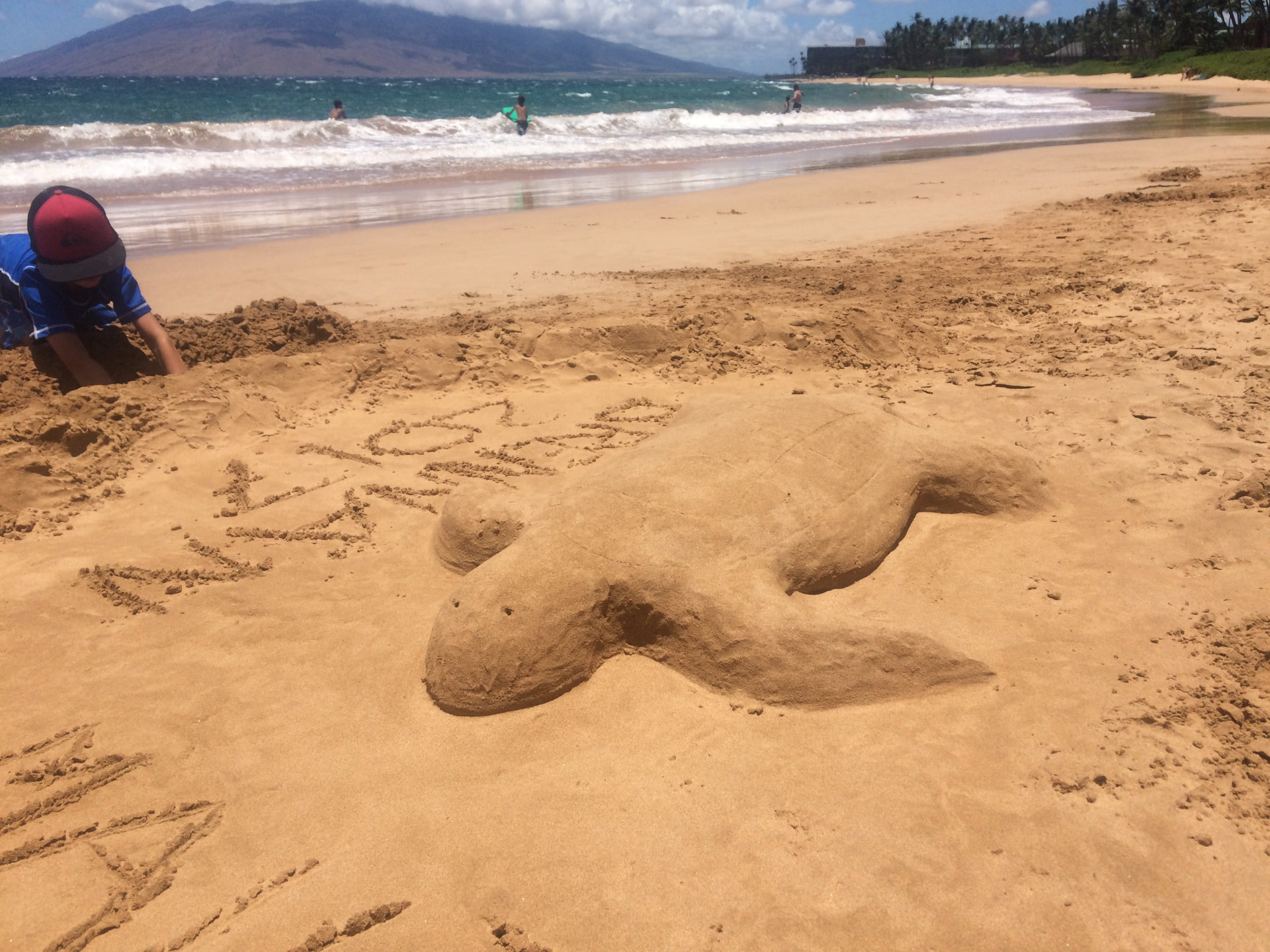 Keawakapu Beach sand and gentle waves with West Maui mountains in the distance