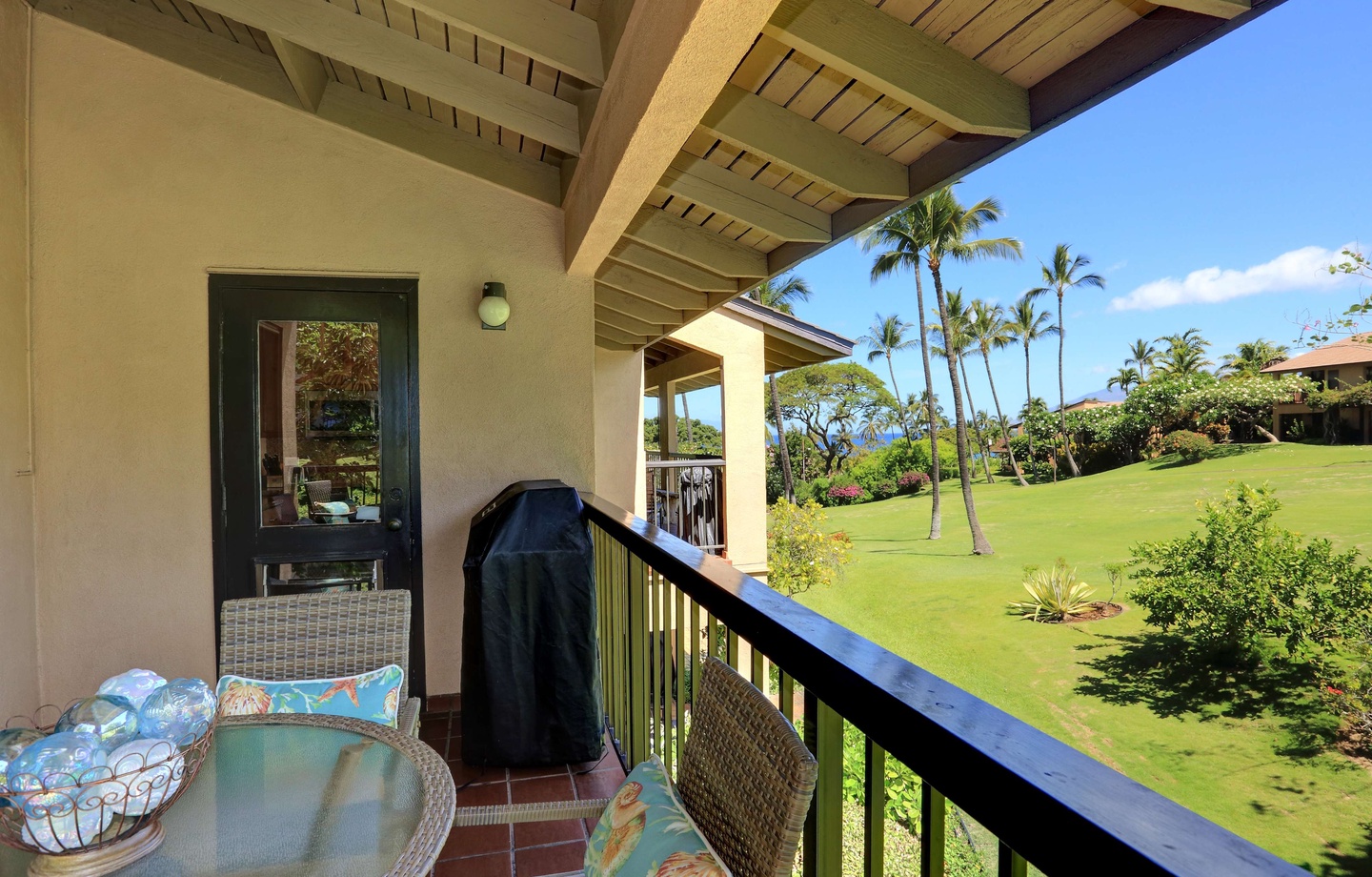 Private lanai at Wailea Ekahi 10F with table, chairs, and garden and ocean views