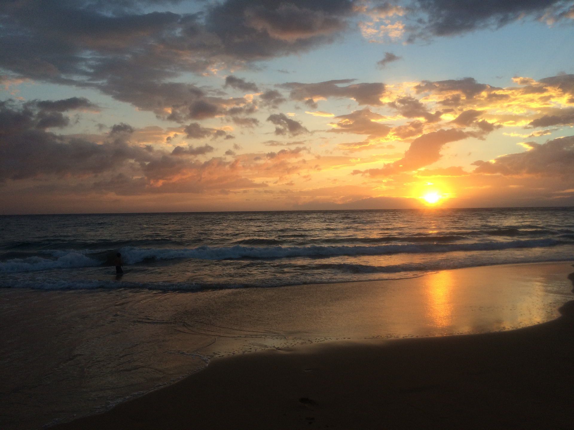 Golden sunset over Keawakapu Beach with waves on the shore